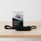 Box of antibacterial styre relief compress on a wooden surface with a white background