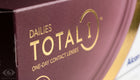 Close-up of a dark burgundy box for Dailies Total 1 One-Day Contact Lenses, featuring gold lettering and logo.