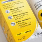 Close-up of a yellow skincare box labeled 'STEP 2 - CLEANSE' with text about cleansing, antibacterial action, and gentle ingredients, alongside partial text for another product in the background.