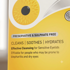 Close-up of a yellow skincare product box with a large yellow-and-white eye graphic and text reading 'PRESERVATIVE & SULPHATE FREE', 'CLEANS | SOOTHES | HYDRATES', and 'Effective Cleansing for Sensitive Eyelids'.