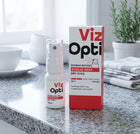 Viz Opti double-action eyelid mist shown as a white spray bottle next to its red and white retail box on a granite kitchen countertop.