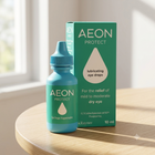 AEON PROTECT eye drops bottle and packaging box on a light wood table in a bright, sunlit room.