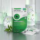 Optase Tea Tree Oil Eyelid Wipes box shown on a reflective surface with two glass beakers containing green liquid, a glass with water droplets, a green leaf sprig, and two individual white wipes in front.