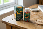 A bottle and box of eyetamins by Optase Eye Comfort dietary supplements placed on a rustic wooden table near a window.