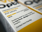 Close-up of Optics Zone Preservative-Free Irritants Eye Drops packaging, showing white and yellow boxes with black text.
