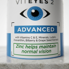 Close-up of a cylindrical supplement bottle labeled VITEYES 2 Advanced, with a white label, blue eye icon, and green text reading 'Zinc helps maintain normal vision' on a light surface.