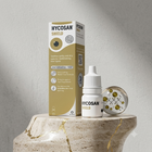 Hycosan Shield hair care product shown with its retail box, a small white bottle with dropper, and a decorative clear sphere on a marble pedestal against a textured light gray wall.