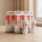 Ursapharm HYLO-FORTE preservative-free artificial tear drops bottles and packaging boxes arranged on a light wooden tabletop with a softly blurred indoor background.
